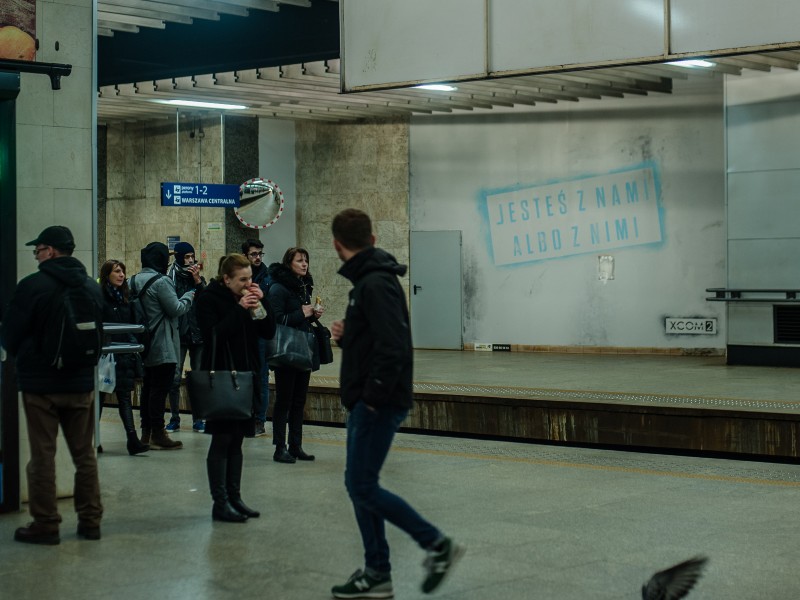 Ein Wandbild im Bahnhof Warszawa Srodmiescie in Warschau Du bist mit uns oder mit ihnen | Gra XCOM2 na PKP Śródmieście | Portfolio