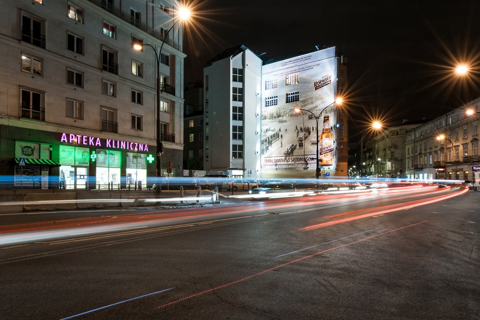 Nocny widok na centrum Warszawy z namalowanym muralem dla Królewskie Niefiltrowane na skrzyżowaniu ulicy Brackiej z Kruczą | Ręcznie malowana kampania reklamowa dla marki Królewskie | Portfolio