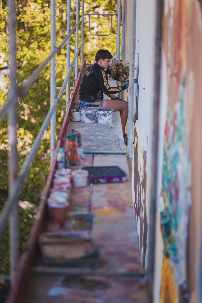 Painter on the scaffolding while working on the basis of the mural | Gardena | Portfolio