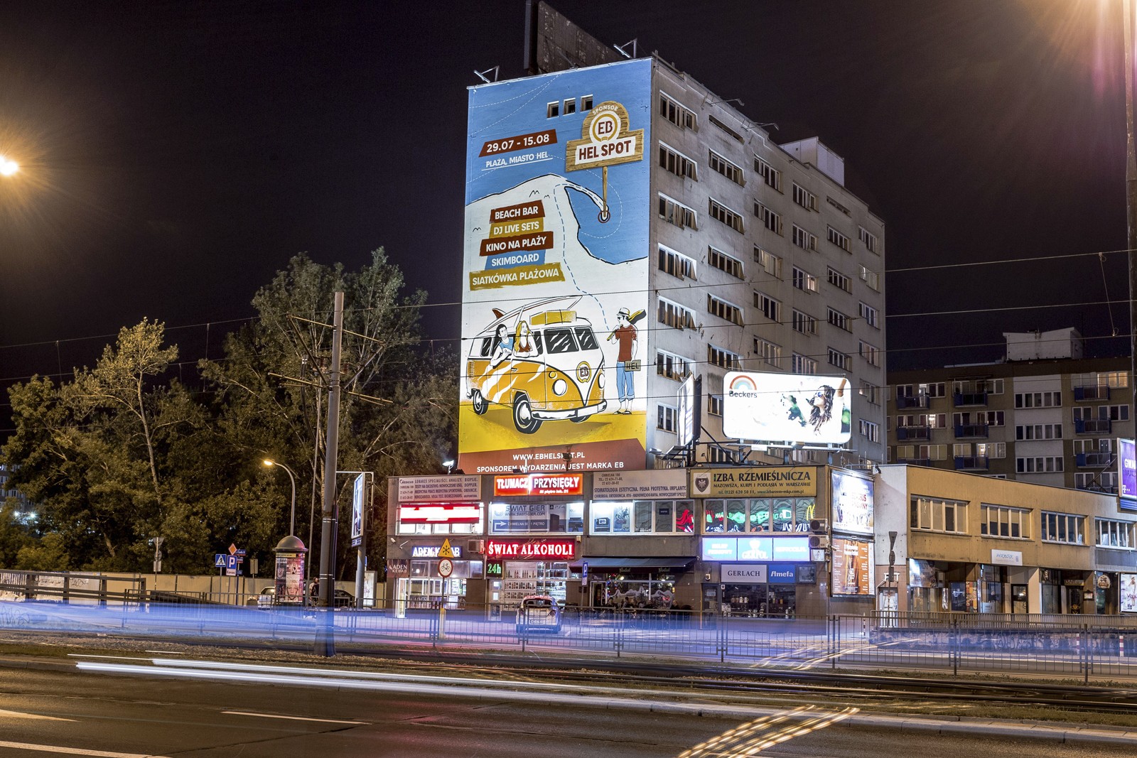 Ansicht auf Chmielna Straße nachts, mit einem Mural als Werbung von EB Hel Spot mit dem Auftritt von De La Soul, Hercules & Love Affair | EB Hel Spot | Portfolio