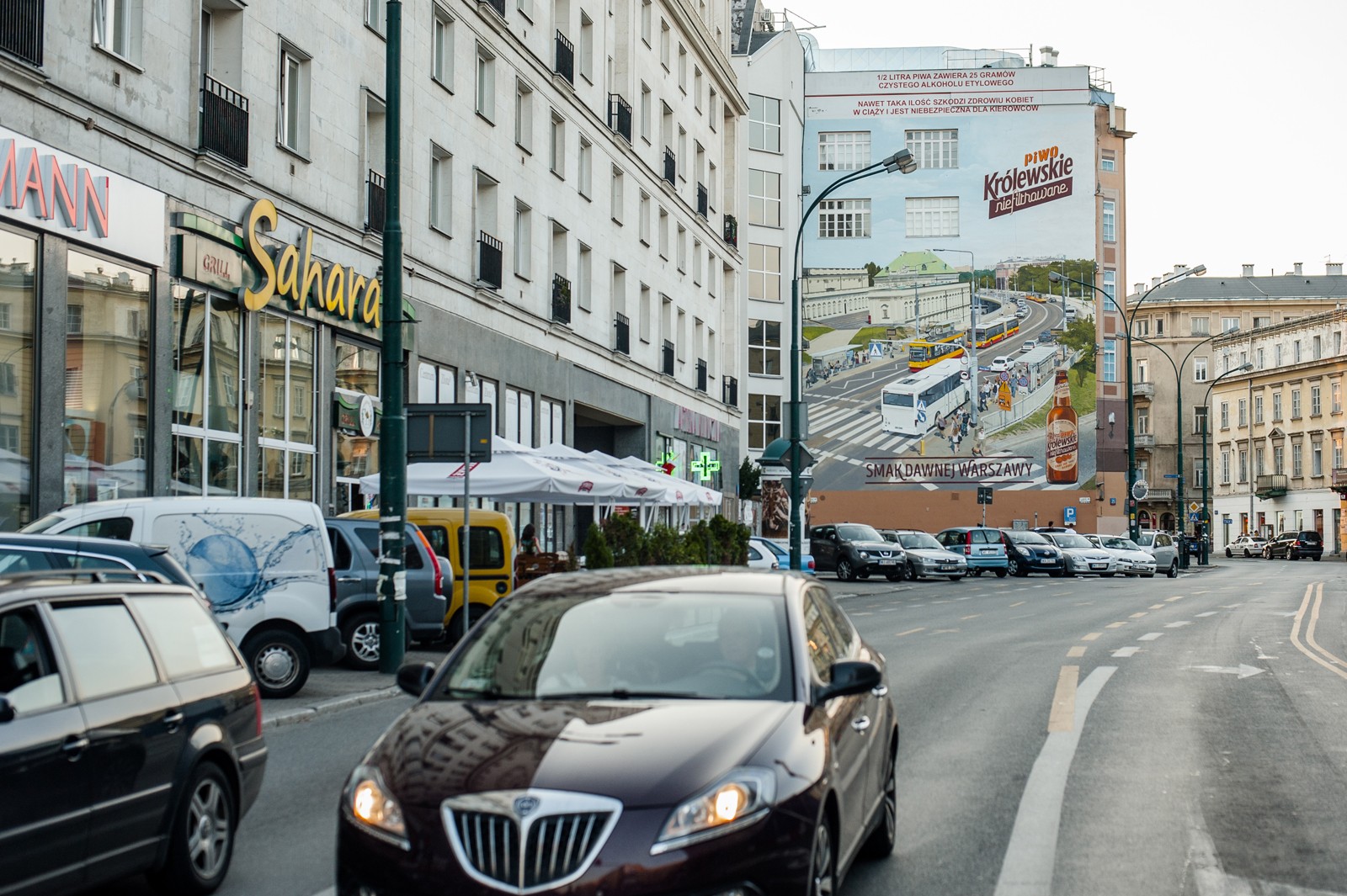 Ansicht auf die Krucza Straße in Warschau mit einem Mural als Werbung der Biermarke Królewskie nicht filtriert im Hintergrund | Krolewskie niefiltrowane | Portfolio