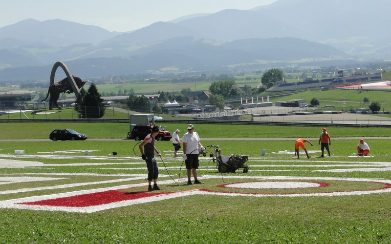 Painting the logotype on grass at formula 1 race track in Spielberg - Austria | Mural malowany na trawie - RedBull Air Race Austria | Portfolio